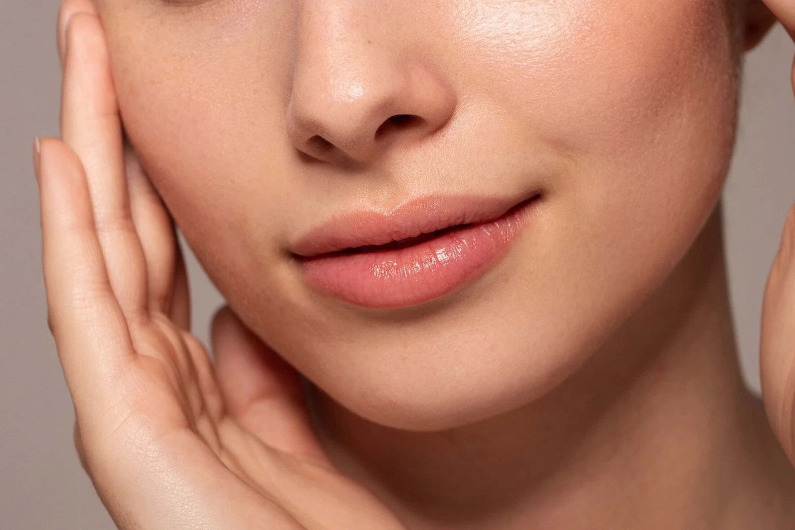 Close-up view of a woman's lower face with smooth lips and defined jawline, representing dermal filler results.