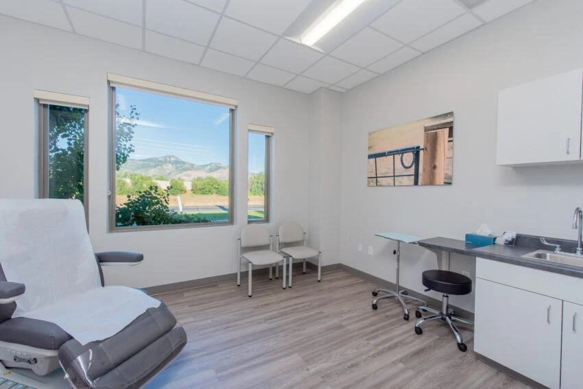 A bright clinical exam room at Dermatology West in Farr West, Utah.